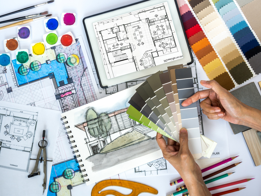 Architect, interior designer working at worktable with color swatch, sketch